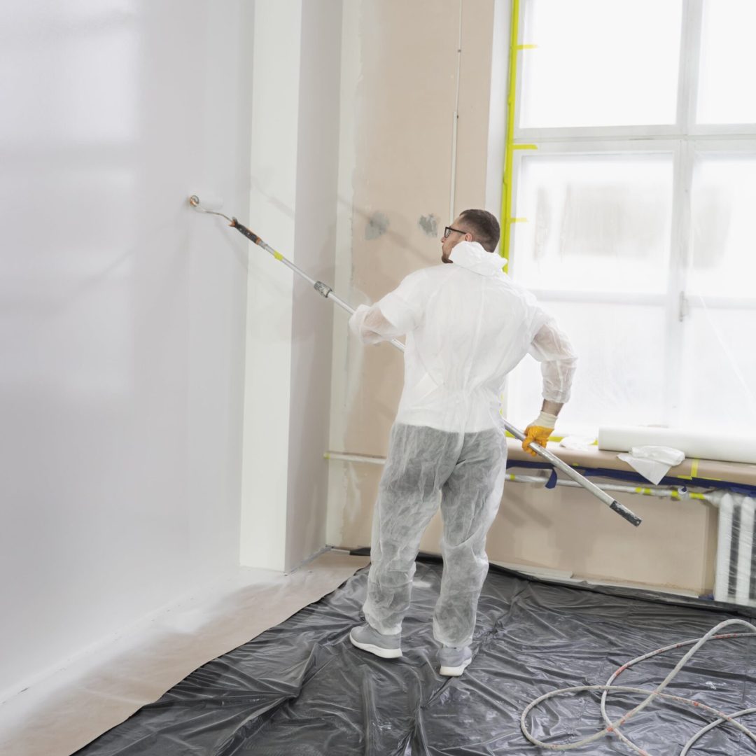 young-worker-painting-wall-full-shot-min